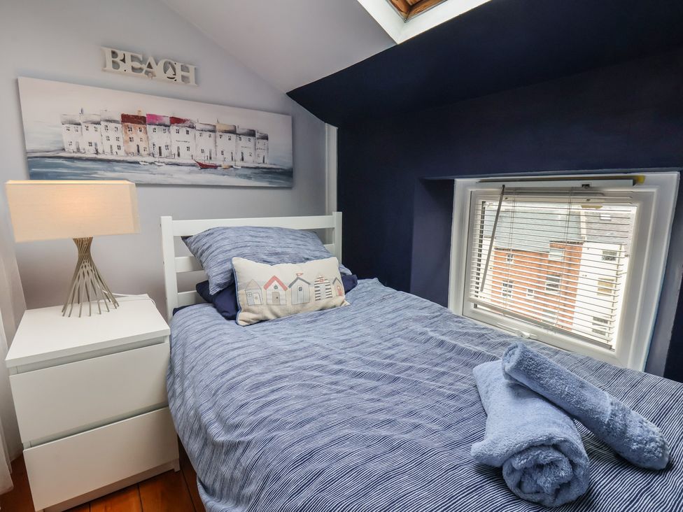 A bedroom with a bed, bedside table, and lamps at The Studio on the Crescent Whitby