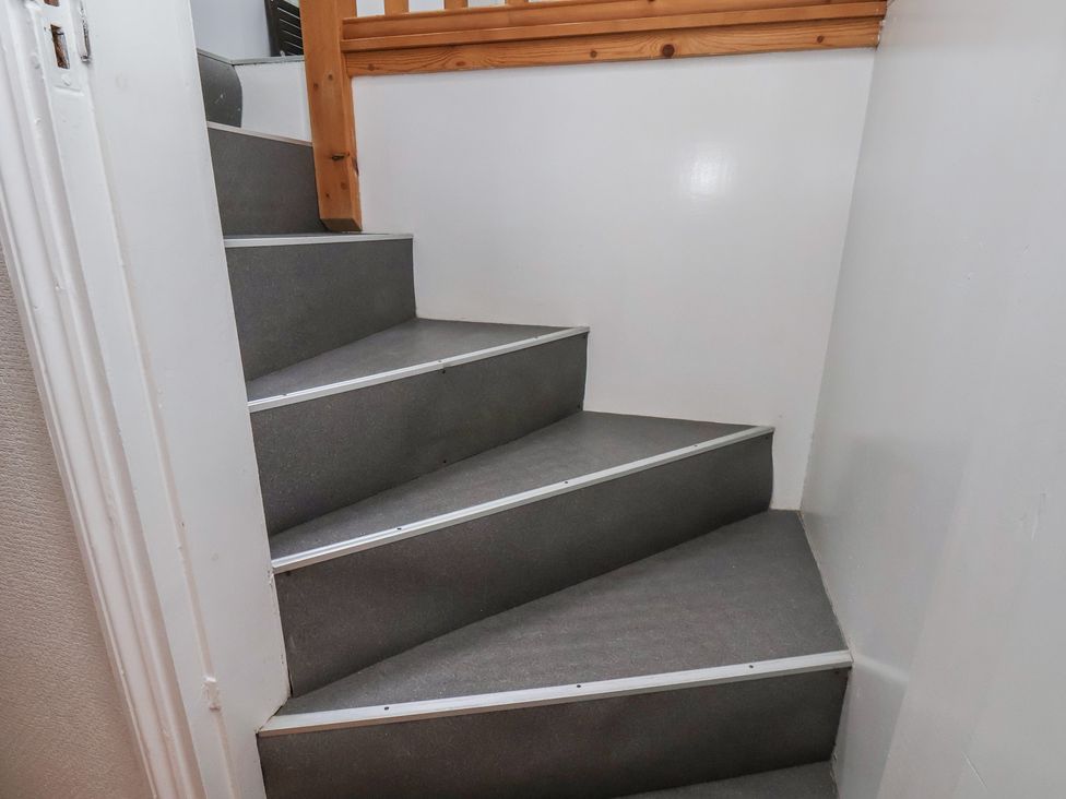 A staircase with a wooden handrail at The Studio on the Crescent Whitby