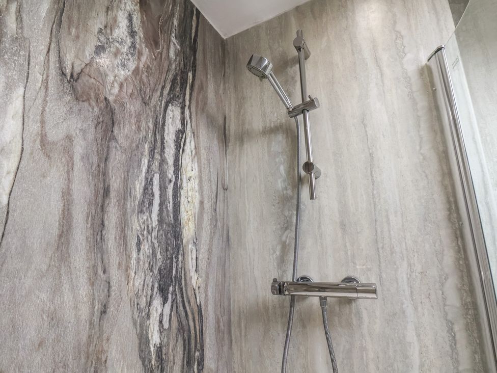 A shower with a mixer and wall tiles at The Studio on the Crescent in Whitby