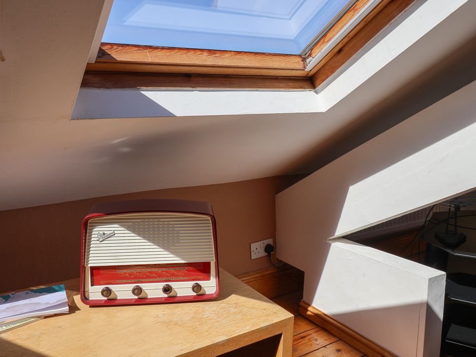 An attic with a radio on a table and a skylight at The Studio on the Crescent in Whitby