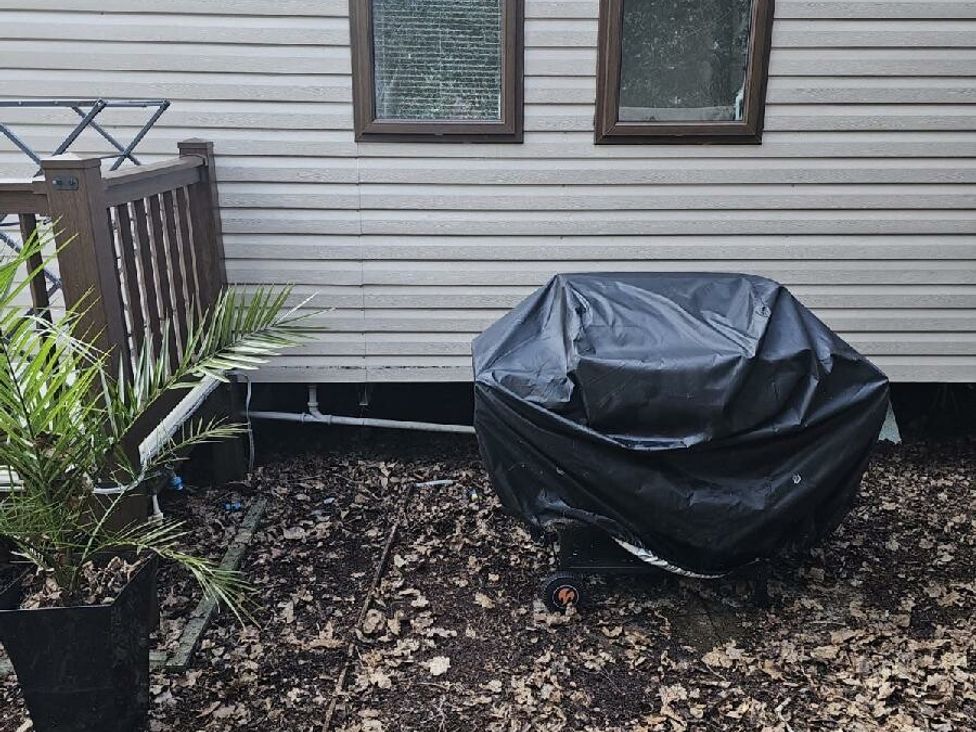 a covered grill next to a potted plant near a building at Wild Duck Holiday Park - Holiday Accommodation 10389 Nr Great Yarmouth