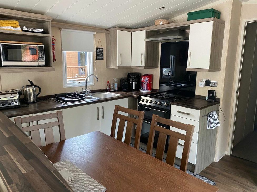 a kitchen with modern appliances and a dining table at Wild Duck Holiday Park - Holiday Accommodation 10389 Nr Great Yarmouth