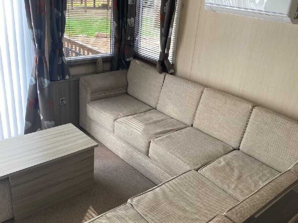 a living room with a sectional sofa and coffee table at Wild Duck Holiday Park - Holiday Accommodation 10389 Nr Great Yarmouth