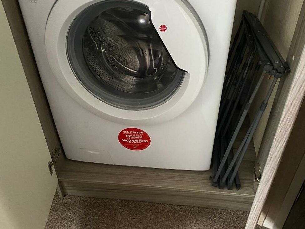 a washing machine and a folding drying rack in a closet at Wild Duck Holiday Park - Holiday Accommodation 10389 Nr Great Yarmouth