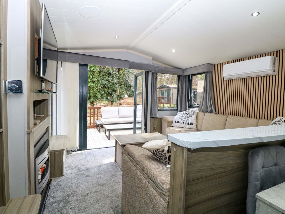 A living room with a sofa and television at Wild Duck Holiday Park in Belton, Norfolk
