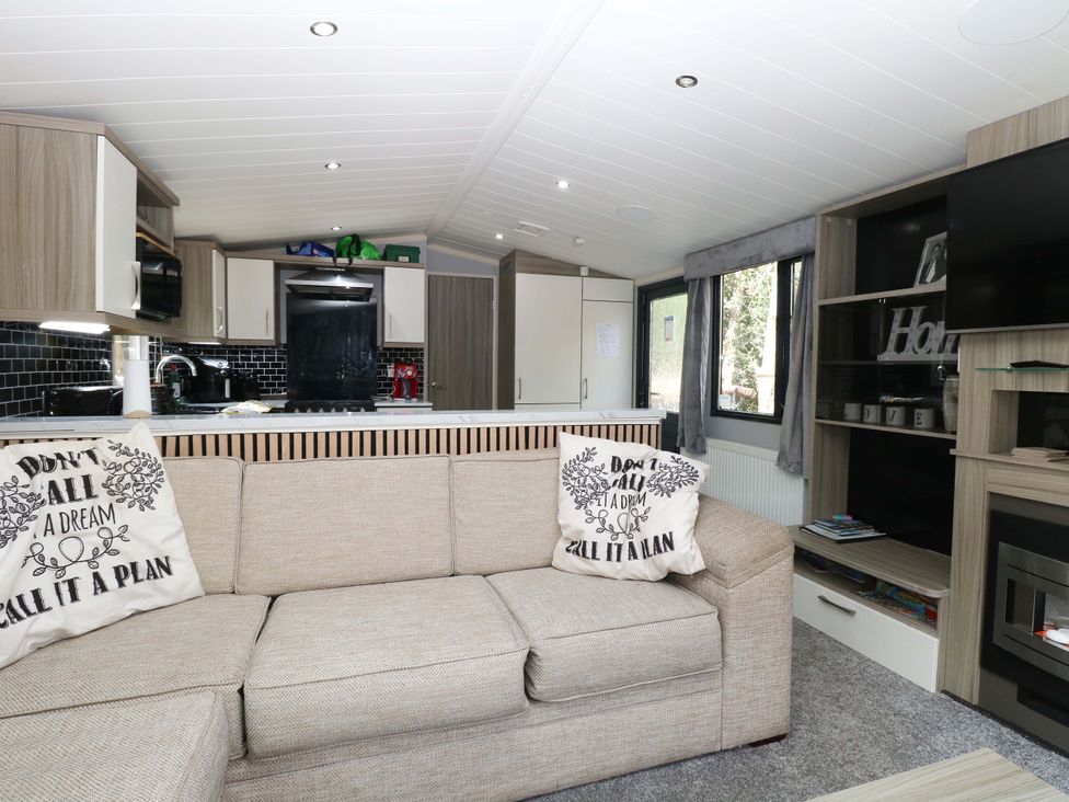 A living room with a sofa and television at Wild Duck Holiday Park in Belton, Norfolk