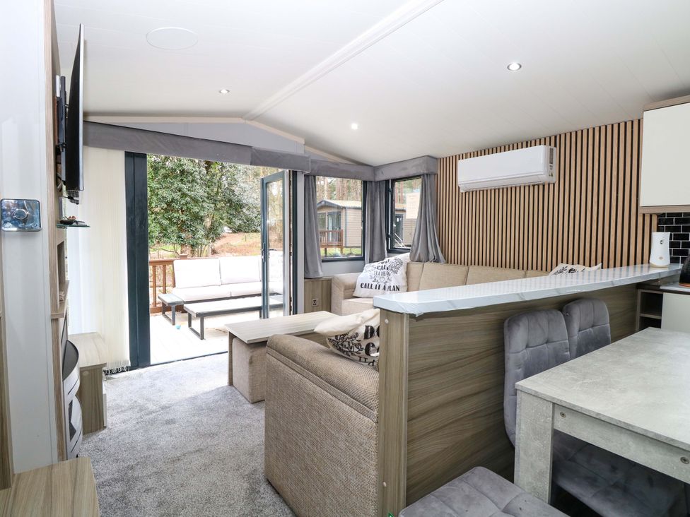 A living room with a sofa and dining table at Wild Duck Holiday Park in Belton, Norfolk