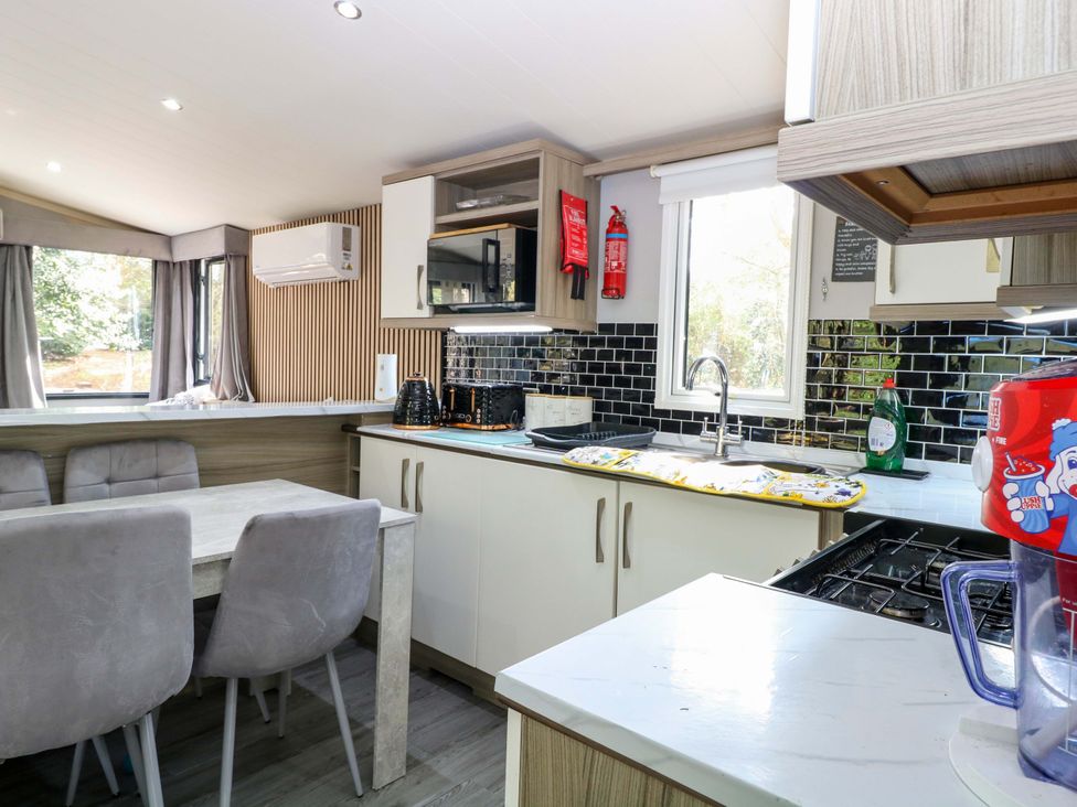 A kitchen with a table and chairs at Wild Duck Holiday Park Belton, Norfolk