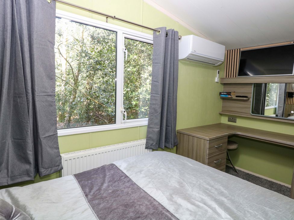 A bedroom with a bed and desk at Wild Duck Holiday Park, Belton, Norfolk