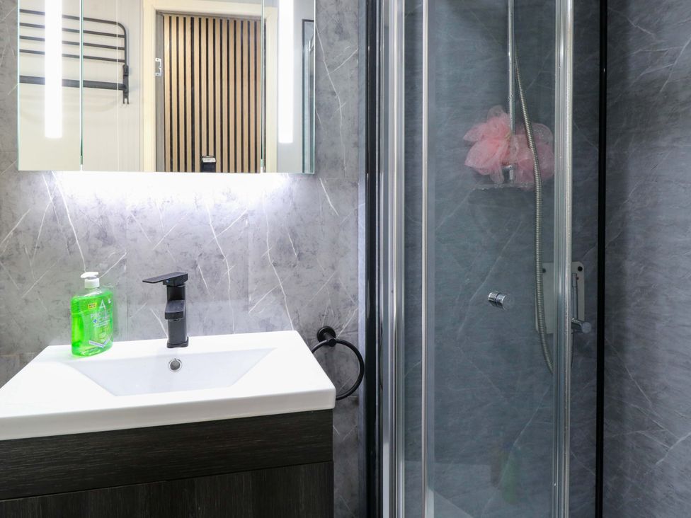 A bathroom with a sink and shower at Wild Duck Holiday Park in Belton, Norfolk