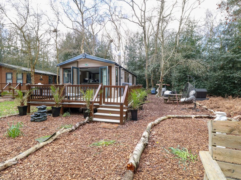 An outdoor area with a cabin and wooden deck at Wild Duck Holiday Park, Belton, Norfolk