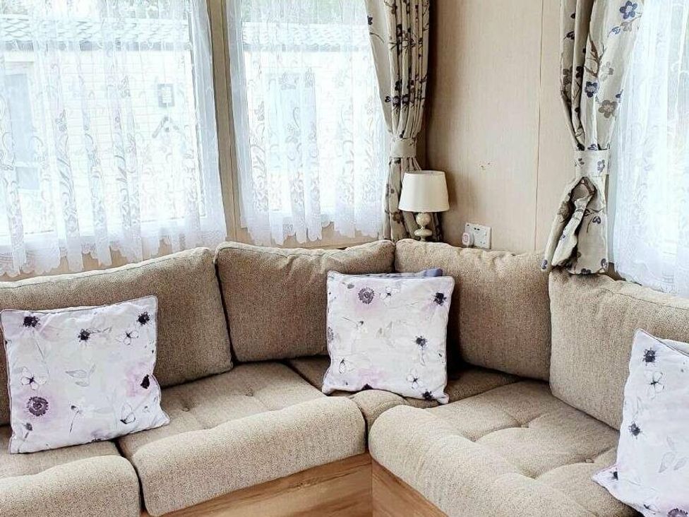 a corner seating area with cushions in a light room at Shorefield Country Park - Holiday Accommodation 10622, Milford On Sea