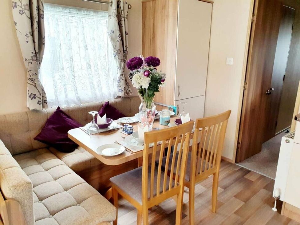 a dining area with a table and chairs and a sofa at Shorefield Country Park - Holiday Accommodation 10622 in Milford On Sea
