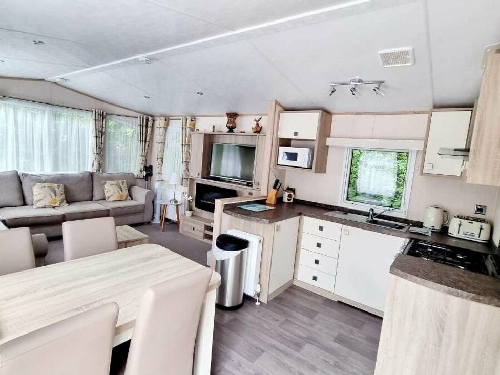 a kitchen and living area with a sofa, dining table, and appliances at Shorefield Country Park - Holiday Accommodation 10821, Milford On Sea