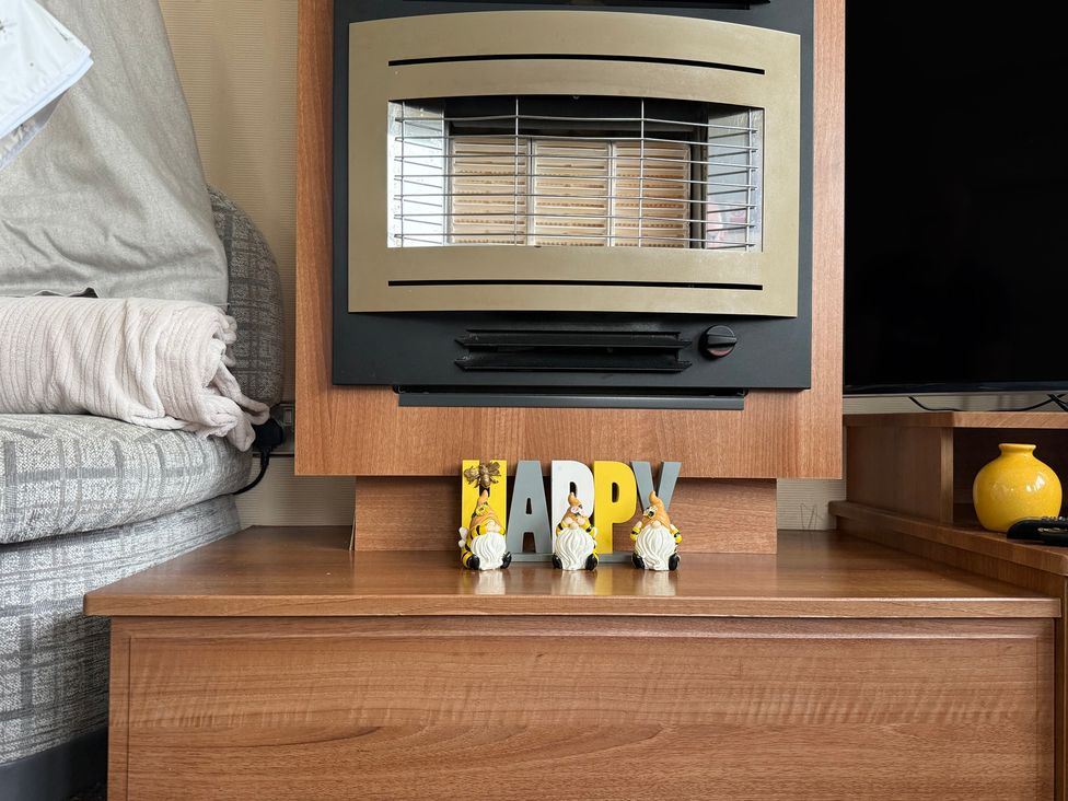 A living room with a fireplace and decorative items at Cala Gran Holiday Park - Holiday Accommodation 10830 in Fleetwood