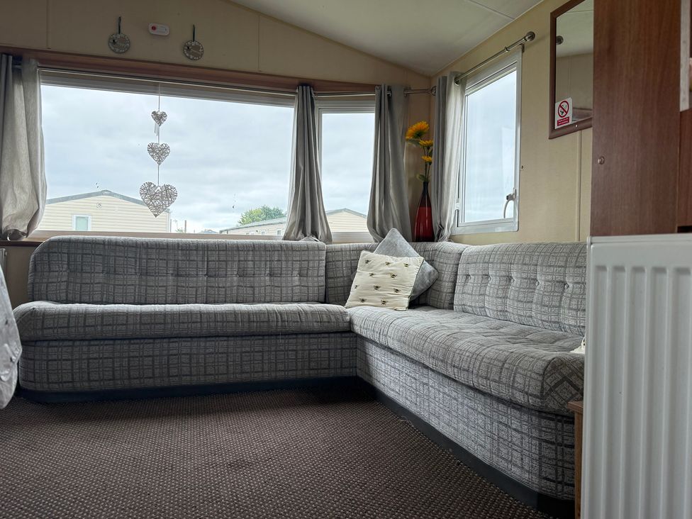 A living room with a sofa and a flower vase at Cala Gran Holiday Park - Holiday Accommodation 10830, Fleetwood