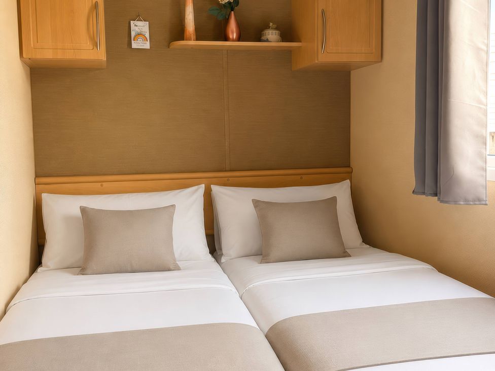 A bedroom with two beds and a shelf at Cala Gran Holiday Park - Holiday Accommodation 10830 Fleetwood