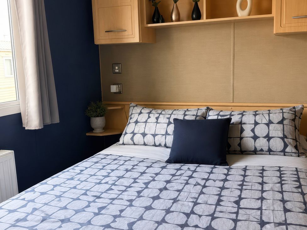 A bedroom with a bed and shelf at Cala Gran Holiday Park - Holiday Accommodation 10830, Fleetwood