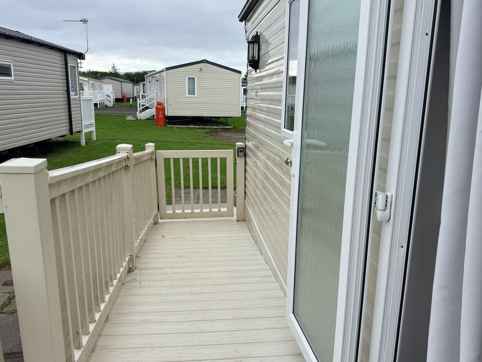 A deck area with a handrail and door at Cala Gran Holiday Park - Holiday Accommodation 10830, Fleetwood