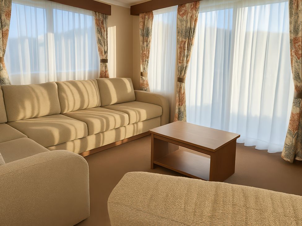 A living room with a sofa and coffee table at Freshwater Beach Holiday Park - Holiday Accommodation 12281 in Burton Bradstock