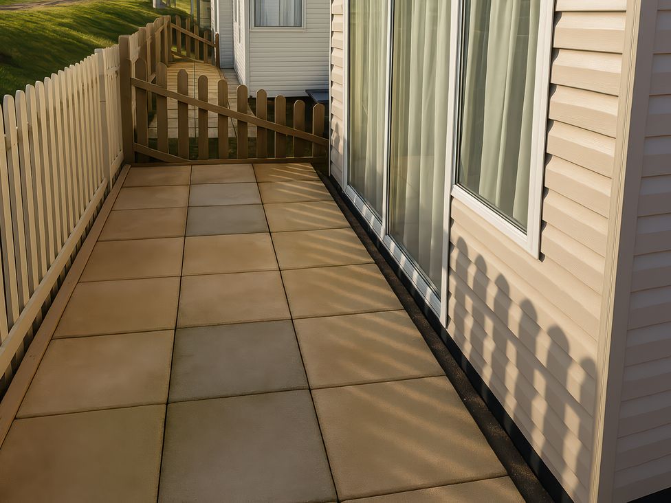 A patio with a sliding door and fence at Freshwater Beach Holiday Park - Holiday Accommodation 12281, Burton Bradstock