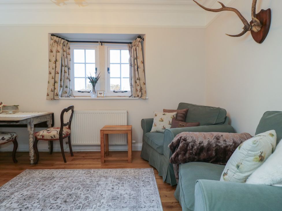 A snug with a sofa and a table at Maud Heath's Snug in Chippenham