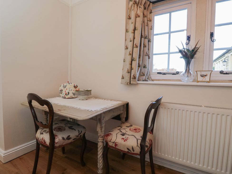 A dining area with a table and chairs at Maud Heath's Snug in Chippenham