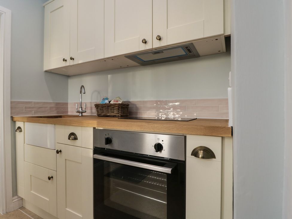 A kitchen with a sink and oven at Maud Heath's Snug in Chippenham