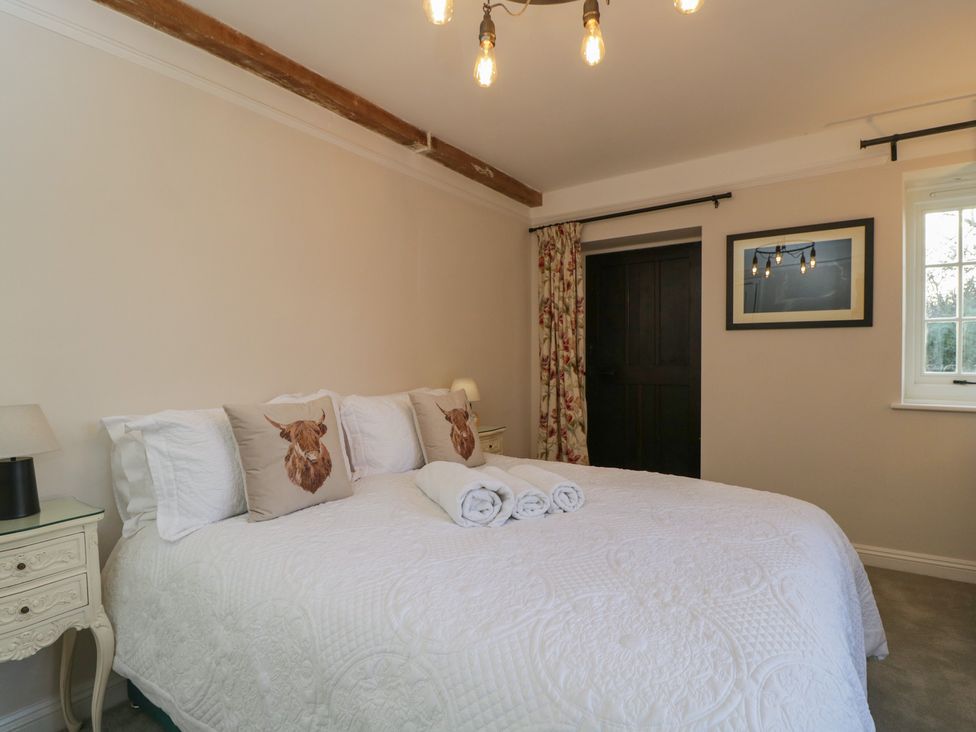 A bedroom with a bed and nightstand at Maud Heath's Snug in Chippenham