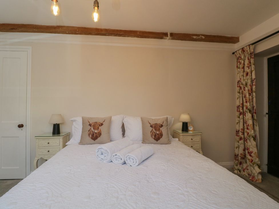 A bedroom with a bed and nightstands at Maud Heath's Snug in Chippenham