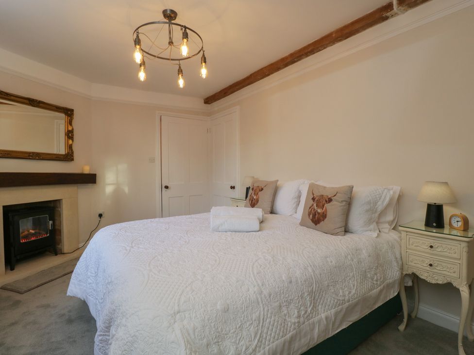 A bedroom with a bed and nightstand at Maud Heath's Snug in Chippenham