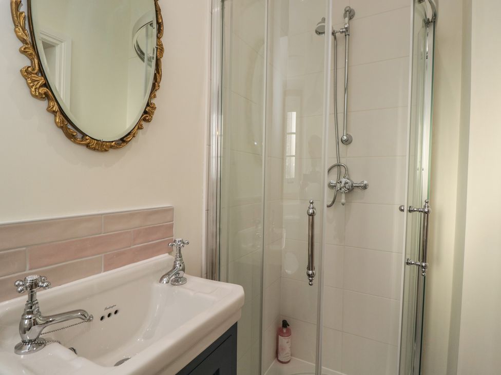 A bathroom with a sink and shower at Maud Heath's Snug in Chippenham