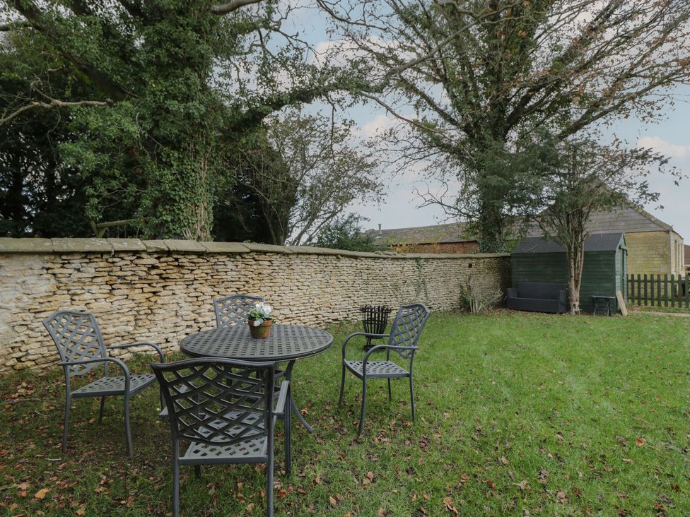A garden with a table and chairs at Maud Heath's Snug in Chippenham