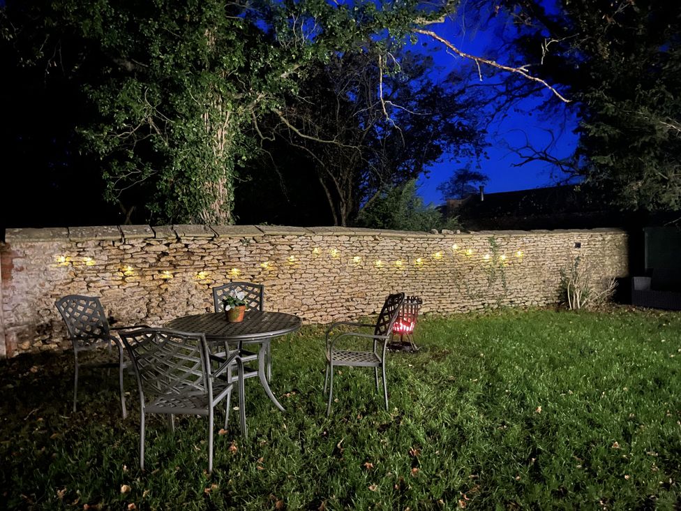 A garden with a table and chairs at Maud Heath's Snug in Chippenham