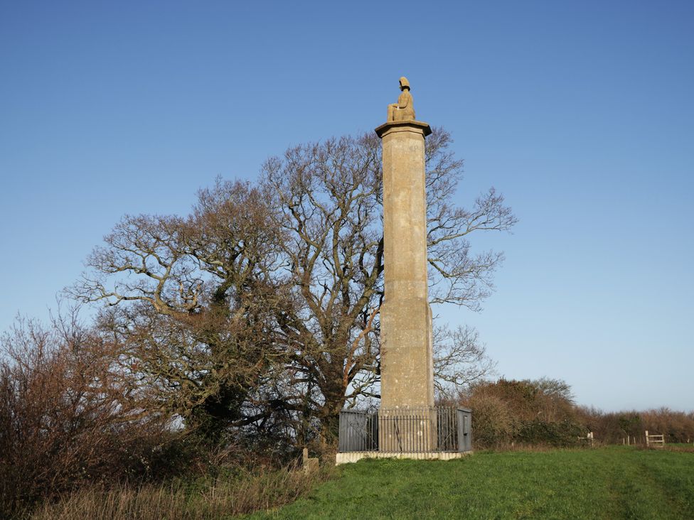 A monument on a hill near a tree at Maud Heath's Snug in East Thytherton