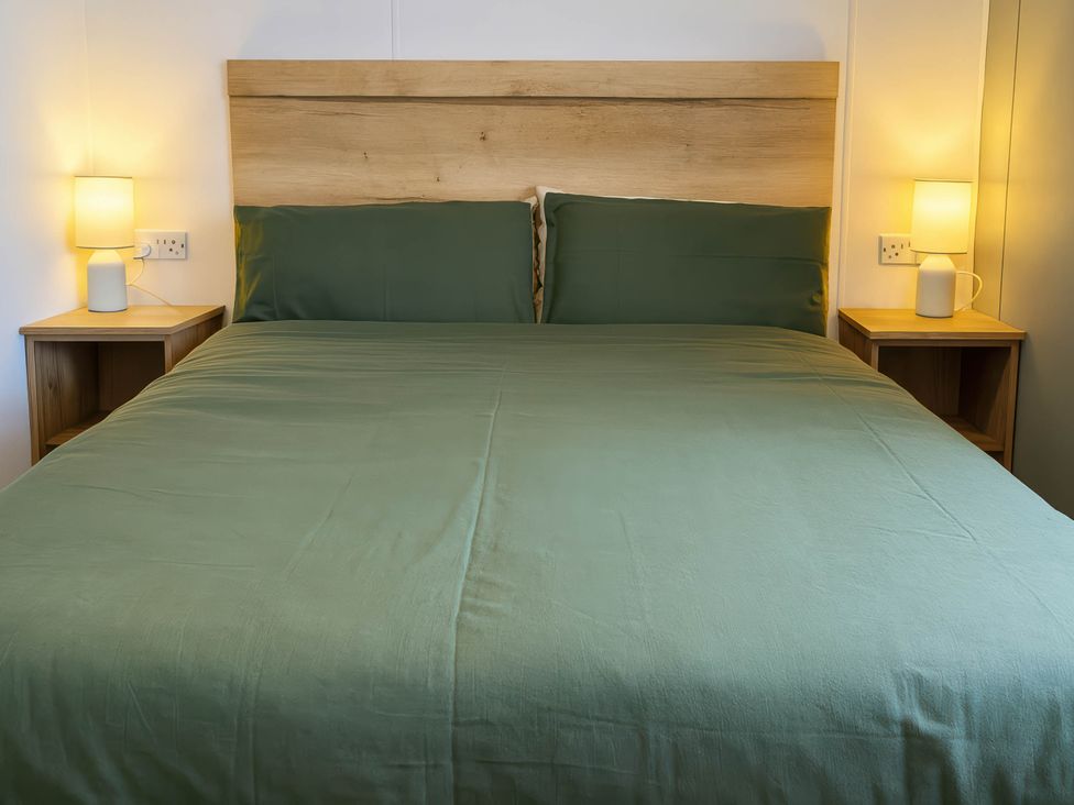 A bedroom with a bed and bedside tables at Littlesea Holiday Park - Holiday Accommodation 13127, Weymouth