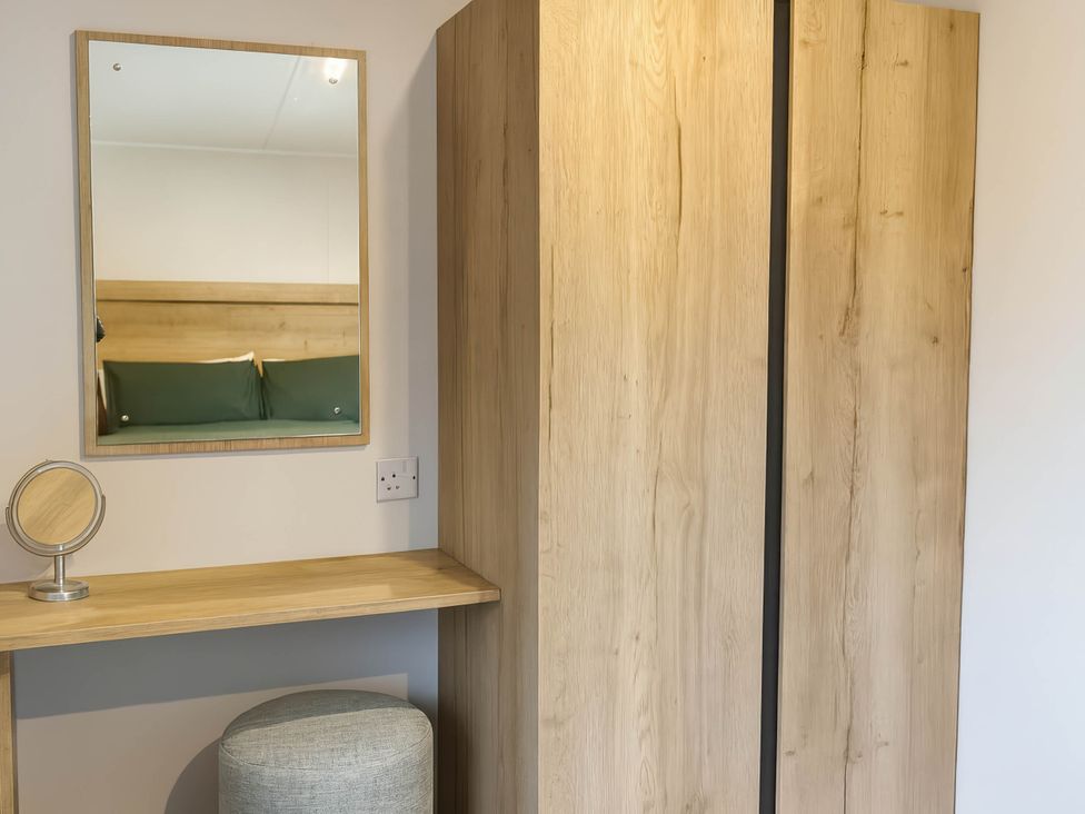 A bedroom with a wardrobe and a mirror at Littlesea Holiday Park - Holiday Accommodation 13127, Weymouth
