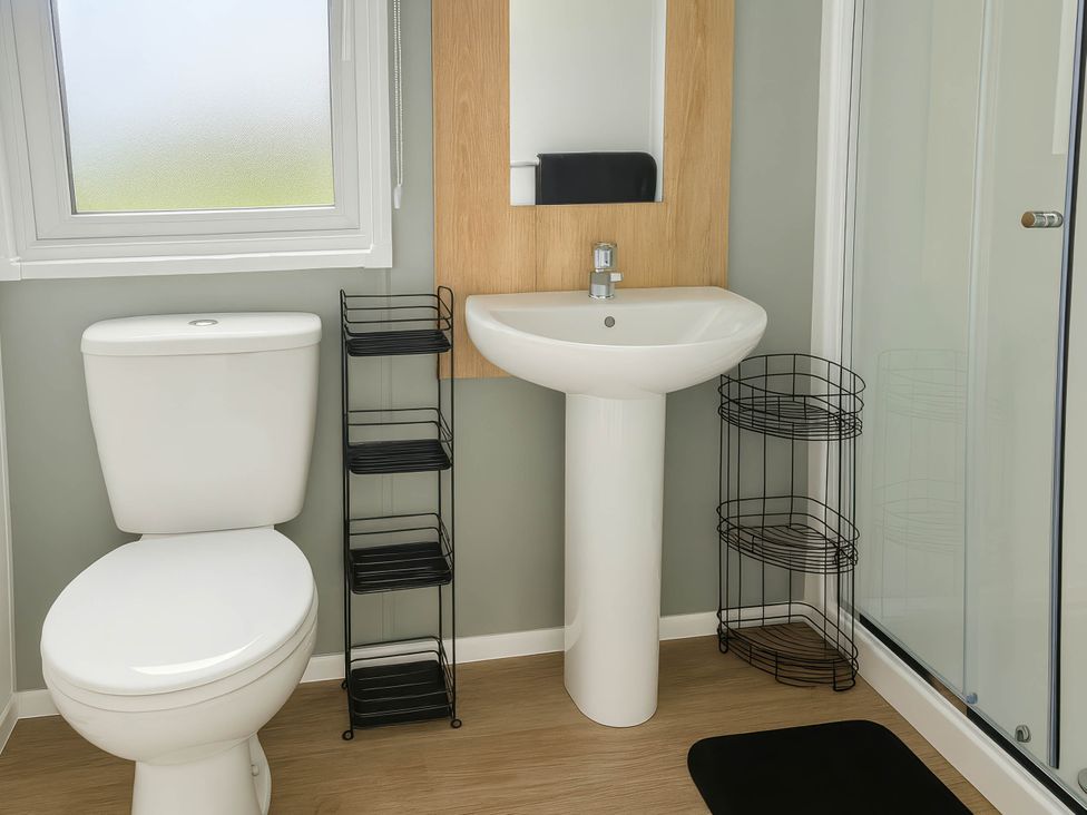 A bathroom with a toilet, sink, and shower at Littlesea Holiday Park - Holiday Accommodation 13127, Weymouth