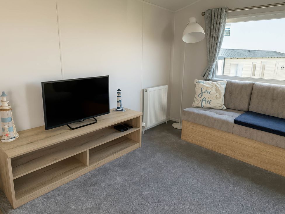 A living room with a television and sofa at Littlesea Holiday Park - Holiday Accommodation 13127 in Weymouth