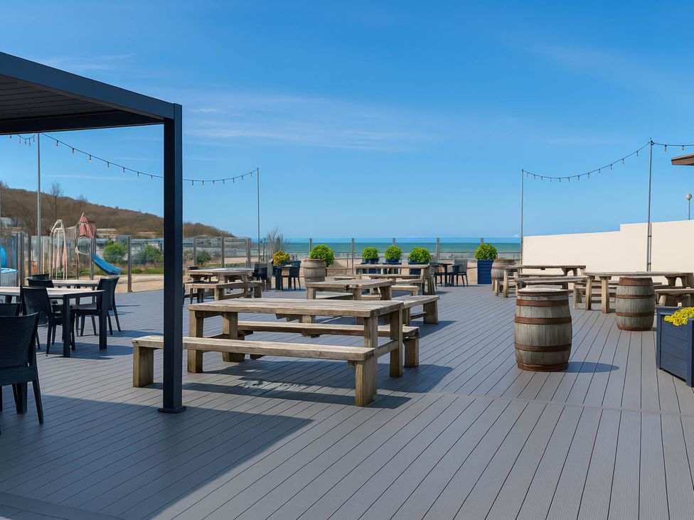 An outdoor area with tables and chairs at Littlesea Holiday Park - Holiday Accommodation 13127 in Weymouth