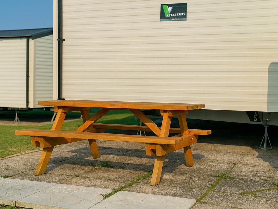 A picnic table in front of a caravan at Littlesea Holiday Park - Holiday Accommodation 13127 Weymouth