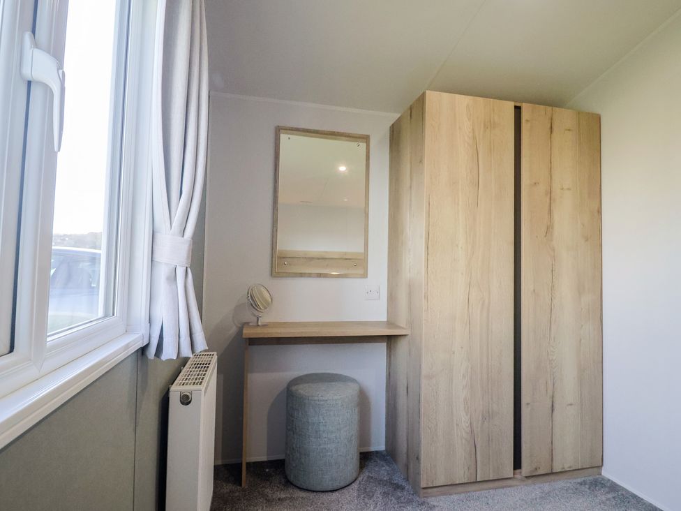 A bedroom with a desk and a wardrobe at Littlesea Holiday Park - Holiday Accommodation 13127, Weymouth