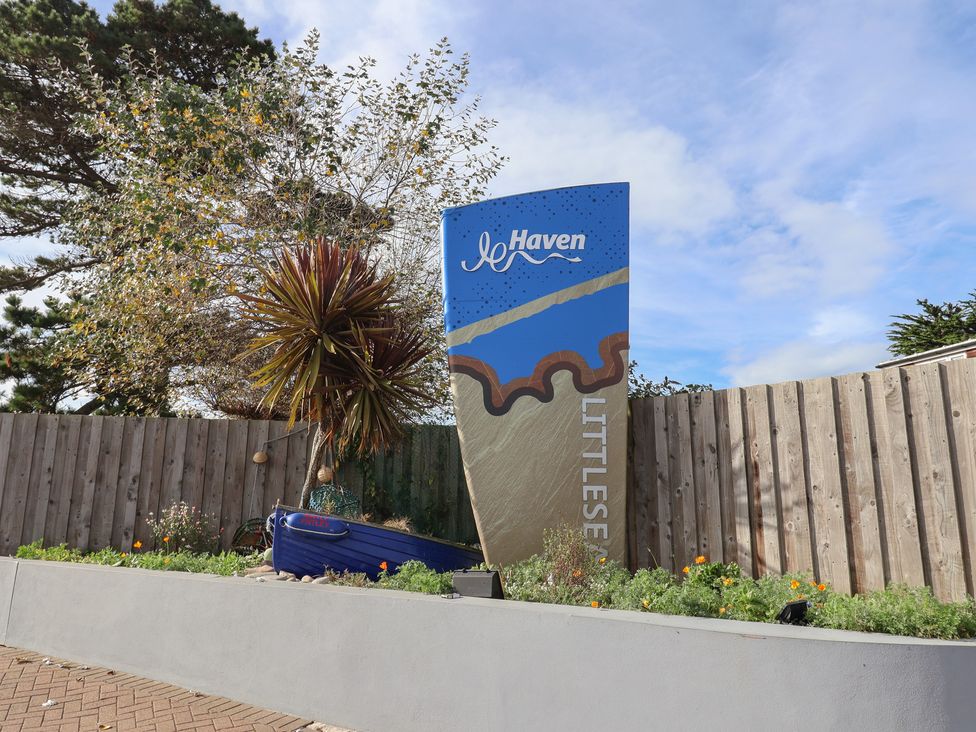 A sign for Littlesea Haven with plants at Littlesea Holiday Park - Holiday Accommodation 13127, Weymouth
