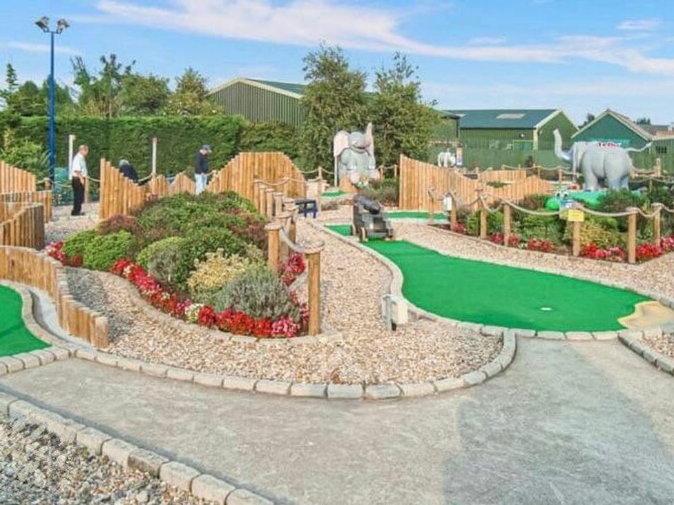 a mini golf course with colorful landscaping and sculptures at Golden Palm Resort - Holiday Accommodation 13363 in Skegness