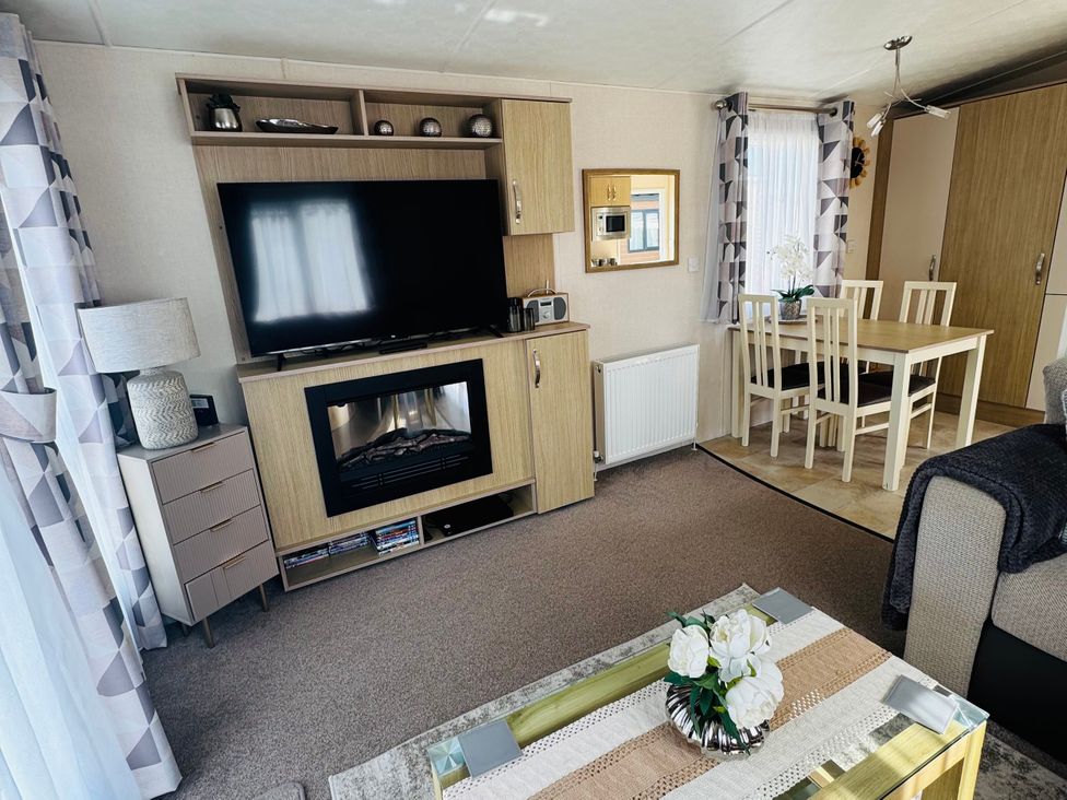 A living room with a television and dining table at Golden Palm Resort - Holiday Accommodation 13363 Skegness