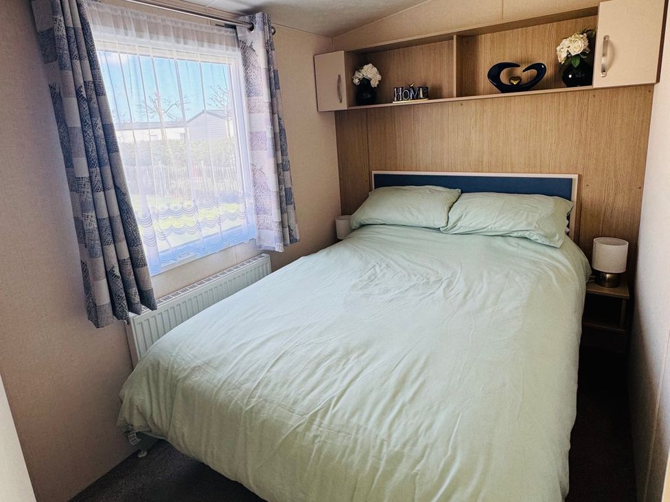 A bedroom with a bed and shelves at Golden Palm Resort - Holiday Accommodation 13363 in Skegness