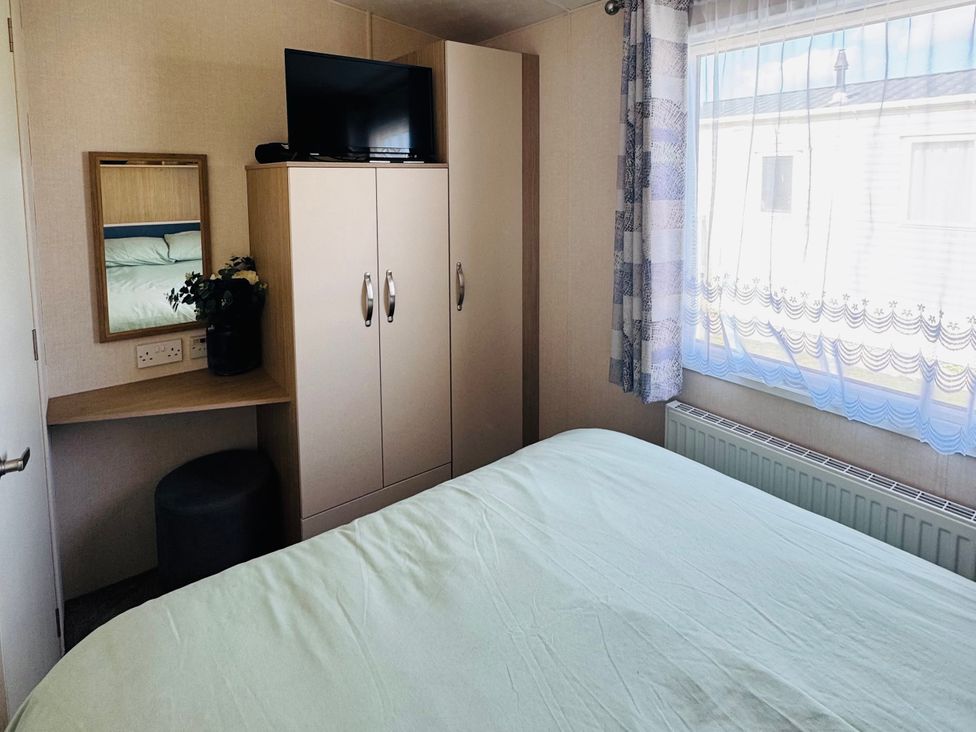 A bedroom with a bed and wardrobe at Golden Palm Resort - Holiday Accommodation 13363 Skegness