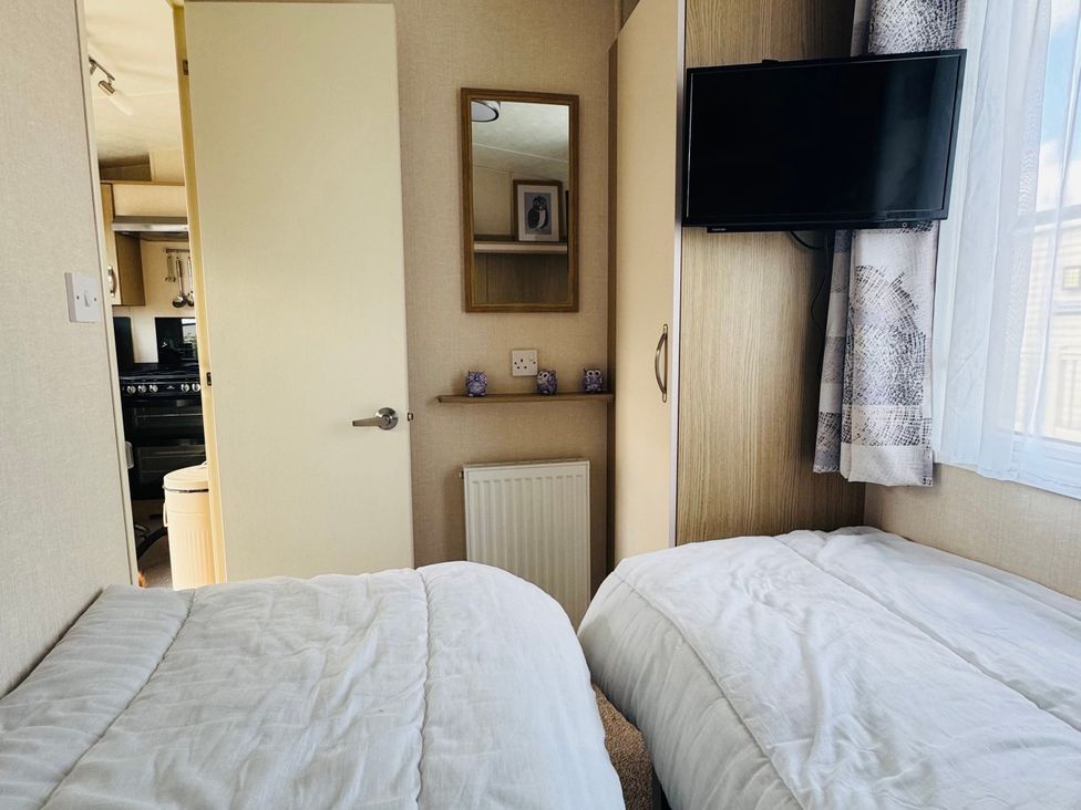 A bedroom with two single beds and a television at Golden Palm Resort - Holiday Accommodation 13363, Skegness