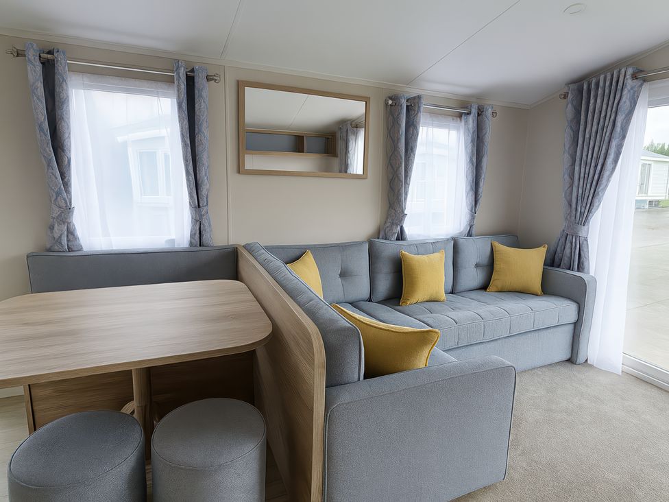 A living room with a sofa and table at Lyons Sunnysands Holiday Park - Barmouth