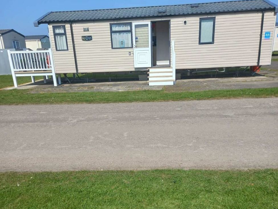 a static caravan with a front porch and steps at Skegness Holiday Park - Holiday Accommodation 13968, Skegness